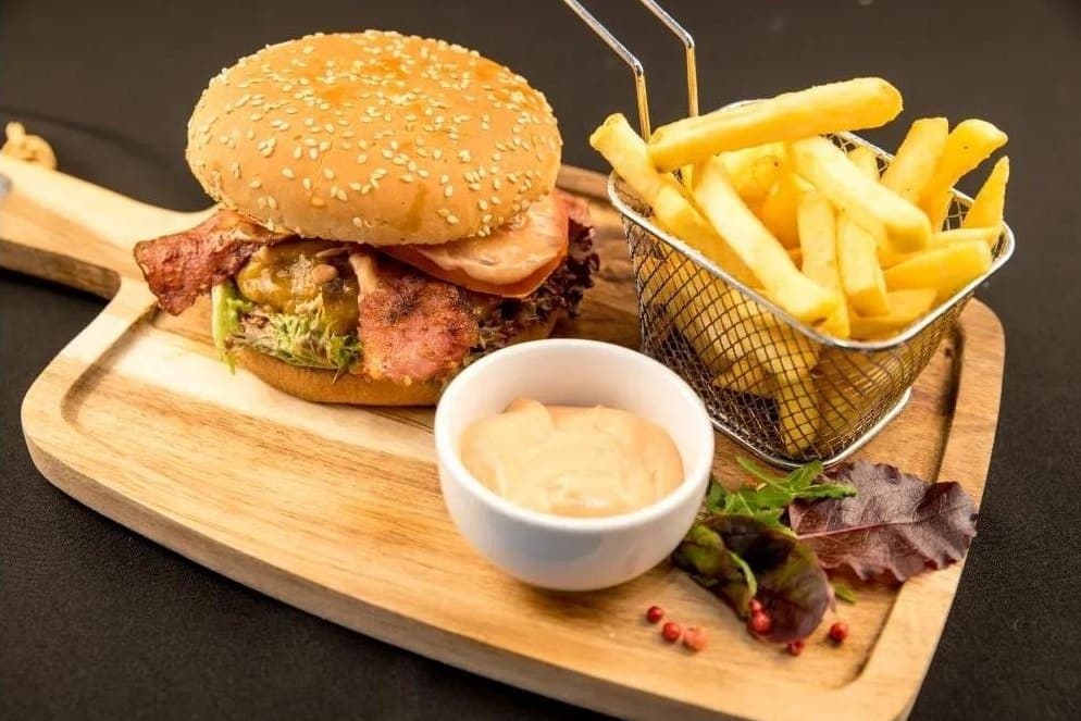 Burger Bubu pe tocător de lemn, cu cartofi prăjiți și sos